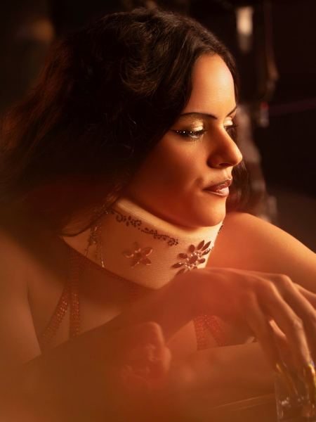 Rosalia as Magick in Euphoria season 3 sitting at the bar and looking off into the distance.