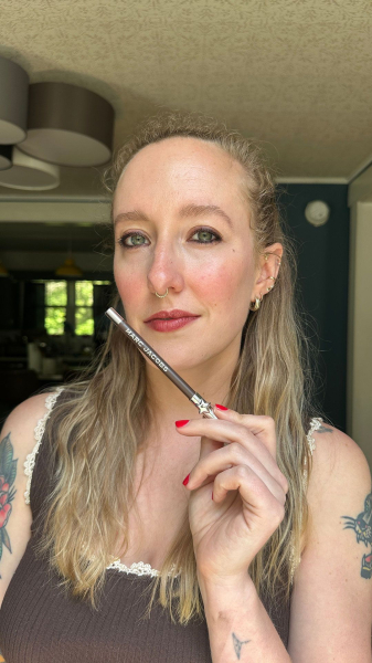 woman holding brown eyeliner